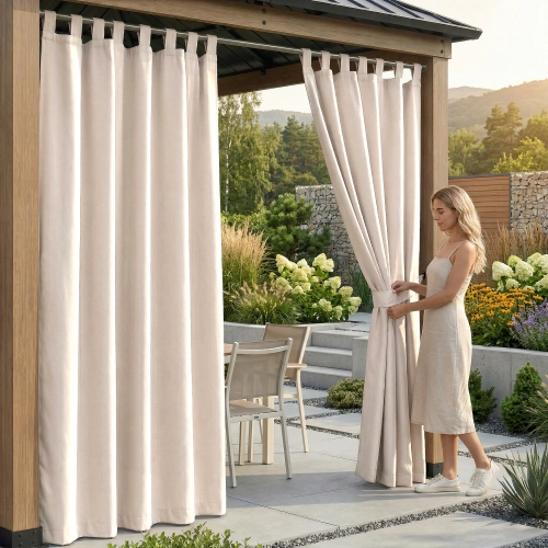 Kobieta na tarasie pod drewnianą pergolą upinająca wodoodporną, kremowo-beżową zasłonę ogrodową na szelkach