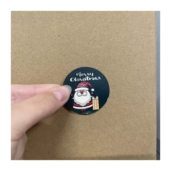 Pojedyncza czerwona naklejka z motywem świątecznym (np. Mikołaj) i napisem 