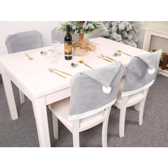 Szary pokrowiec Czapka Mikołaja nałożony na oparcie krzesła w jadalni, tworzący świąteczną dekorację stołu.