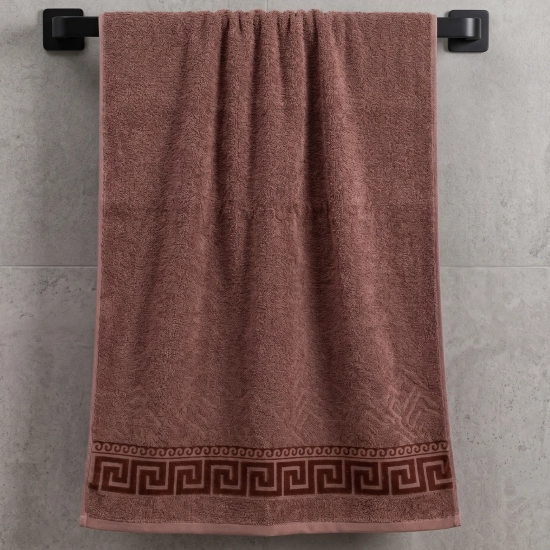 Klasyczny ręcznik łazienkowy 50x100 w kolorze zgaszonego, brudnego różu (lub jasnego brązu) z serii Alba, zawieszony na czarnym wieszaku ściennym.