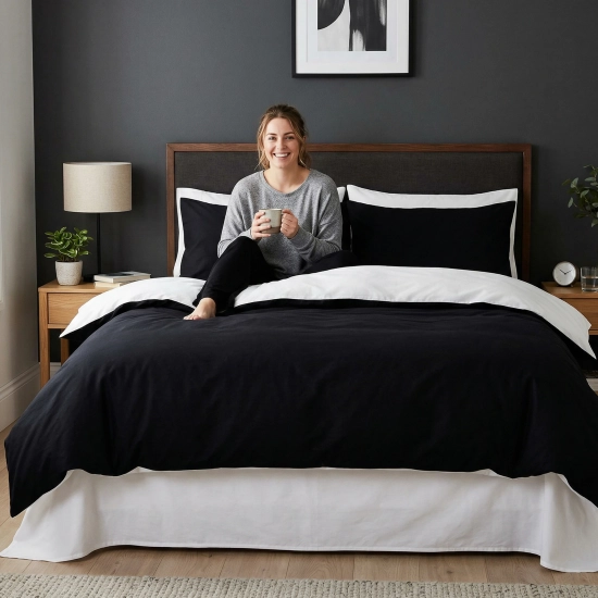 Kobieta siedząca na łóżku z dwustronną pościelą czarno-białą