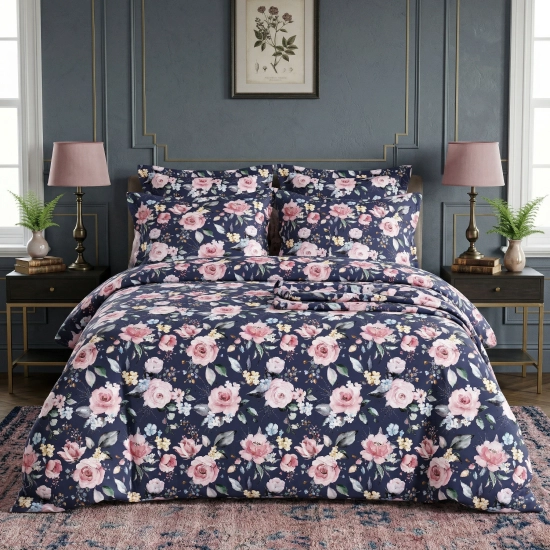 Klasycznie urządzona sypialnia z łóżkiem zaścielonym pościelą J&W we wzór malarskich róż na granatowym tle.