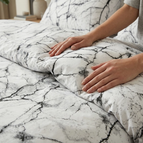 Zbliżenie na dłonie dotykające grubej bawełny premium; wyraźnie widoczny rysunek perfekcyjnej struktury kamienia na bieli.