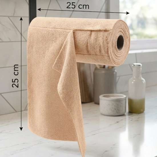 Rolka beżowych ściereczek z mikrofibry zawieszona poziomo na czarnym stojaku w jasnej kuchni. Widoczne czarne strzałki i napisy z wymiarami: 25 cm szerokości rolki i 25 cm długości ściereczki.