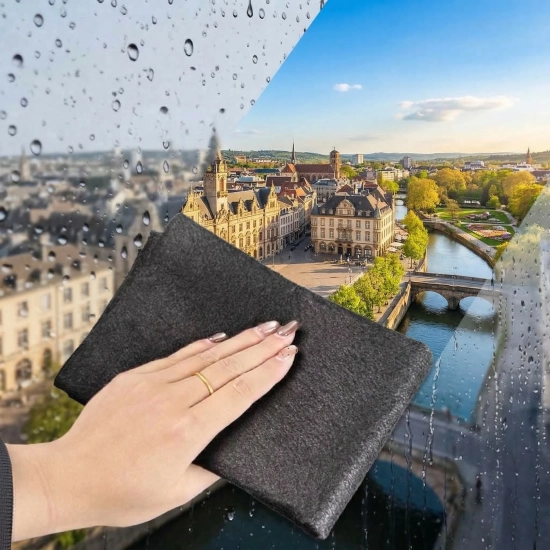 Ręka przecierająca zaparowaną mokrą szybę szarą ściereczką bez smug odsłaniając widok na miasto