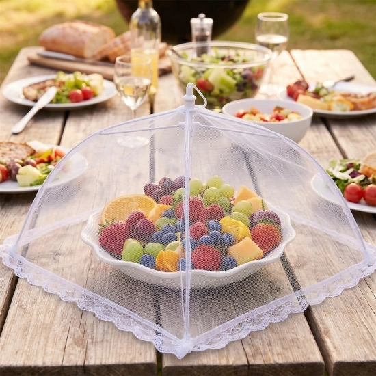 Siatka ochronna moskitiera na żywność owoce na stole w ogrodzie