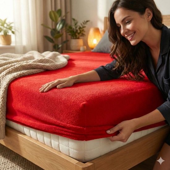 Kobieta zakładająca czerwone prześcieradło nieprzemakalne frotte z gumką na materac w przytulnej sypialni, polski produc