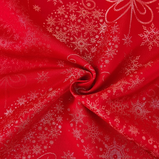 Zbliżenie na srebrne bombki i śnieżynki na czerwonym obrusie świątecznym