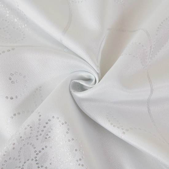 Detal tkaniny – błyszczące srebrne gwiazdki na białym tle