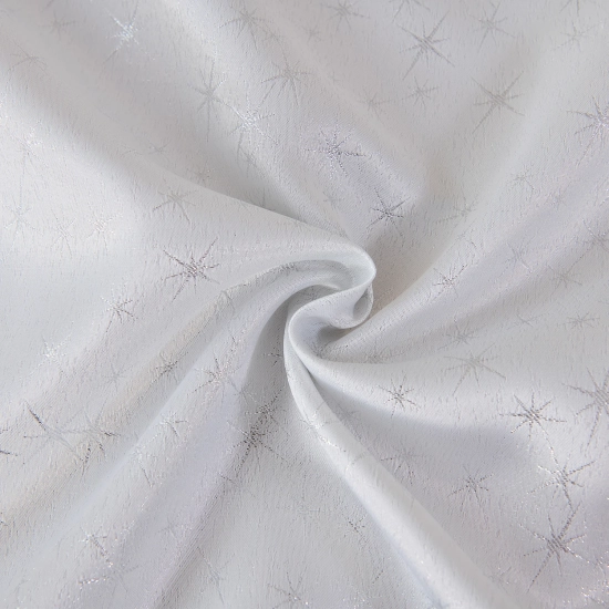 Detal tkaniny – połyskujące srebrne gwiazdki na białym obrusie