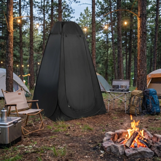 Zamknięty czarny namiot PRIVIO rozbity na campingu w lesie obok ogniska o zmierzchu.