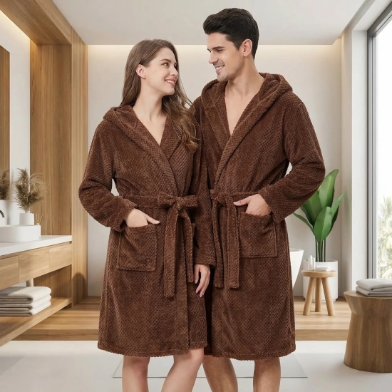 Uśmiechnięta para w łazience ubrana w grube brązowe szlafroki kąpielowe z kapturem z miękkiej mikrofibry