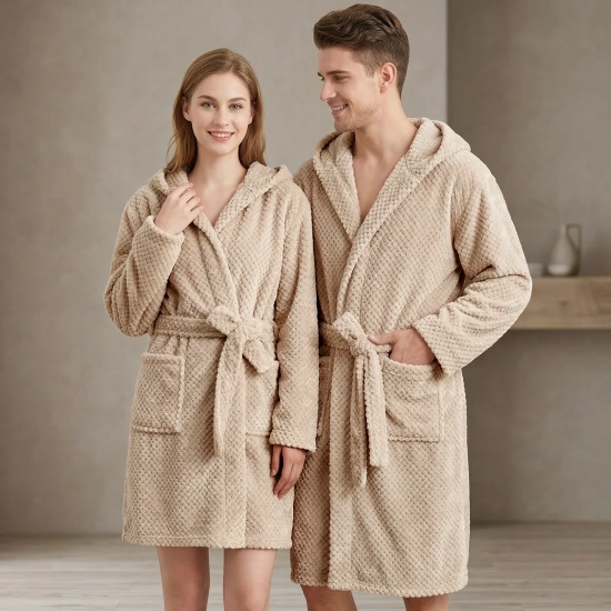 Uśmiechnięta para w łazience ubrana w grube beżowe szlafroki kąpielowe z kapturem z miękkiej mikrofibry