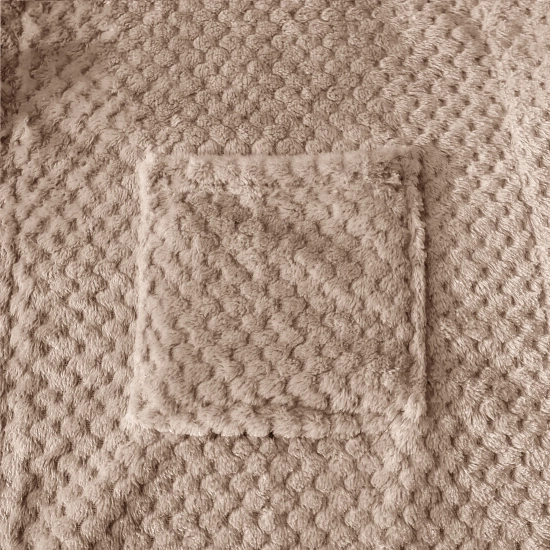 Zbliżenie na puszysty materiał beżowego szlafroka z wytłaczanym wzorem i naszytą pojemną kieszenią