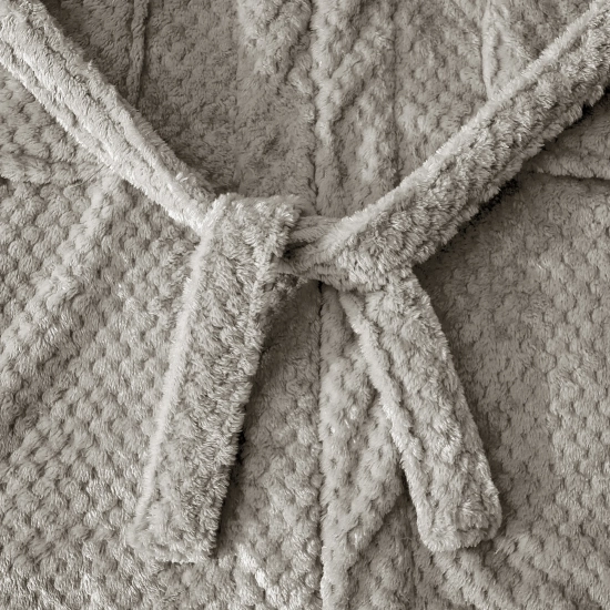 Zbliżenie na puszysty materiał jasnoszarego szlafroka z wytłaczanym wzorem i naszytą pojemną kieszenią