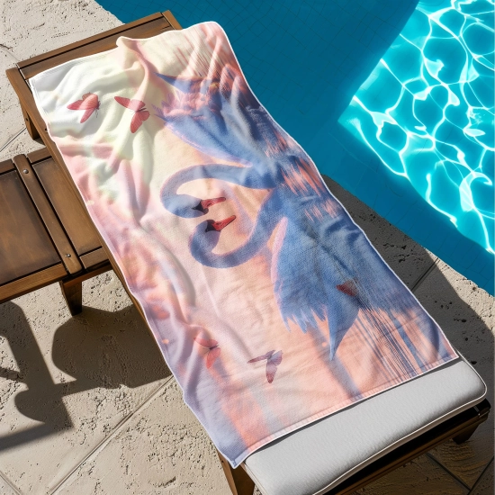 Ręcznik na wakacje z mikrofibry z nadrukiem zakochanych łabędzi rozłożony na leżaku na rajskiej plaży