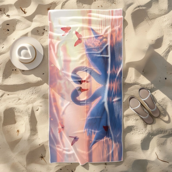 Szybkoschnący ręcznik z mikrofibry w zakochane łabędzie rozłożony płasko na piaszczystej plaży z kapeluszem - TwójDomNa5.pl