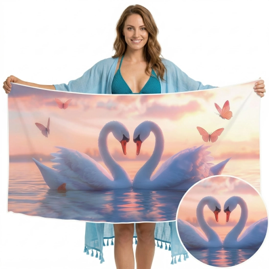 Uśmiechnięta kobieta w błękitnej narzutce trzymająca ręcznik z mikrofibry we wzór łabędzi, zbliżenie na detale ptaków