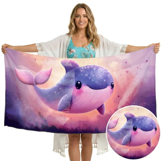 Uśmiechnięta kobieta trzymająca pionowo duży ręcznik XXL z mikrofibry we wzór uroczego wieloryba, zbliżenie na zwierzę