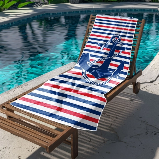 Rozłożony na leżaku basenowym szybkoschnący ręcznik z żeglarską kotwicą, w tle woda w basenie i zieleń.