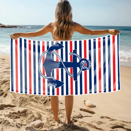 Kobieta na plaży trzymająca rozłożony duży ręcznik plażowy z mikrofibry z marynarskim nadrukiem kotwicy. Sklep TwójDomNa5.pl