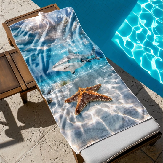 Szybkoschnący ręcznik XXL na leżak z nadrukiem rekina i rozgwiazdy rozłożony przy basenie