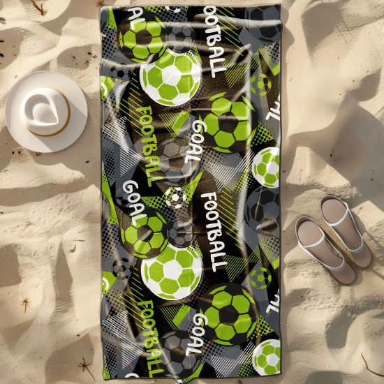 Duży ręcznik plażowy XXL z mikrofibry w sportowy wzór z piłkami nożnymi, rozłożony na piasku obok kapelusza - TwójDomNa5