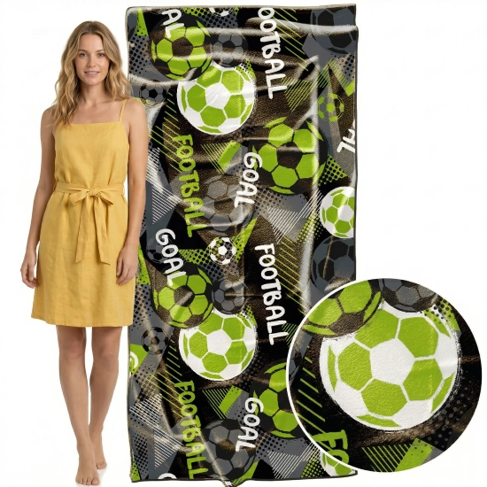 Modelka w żółtej sukience obok pionowo zawieszonego ręcznika XXL z mikrofibry z piłkami nożnymi, zbliżenie na detale