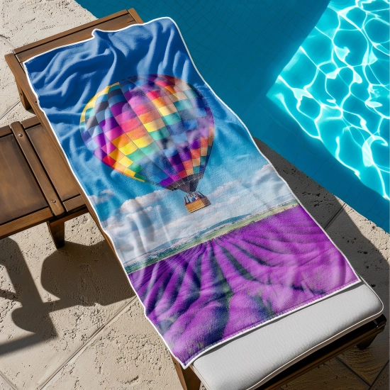 Szybkoschnący ręcznik XXL na leżak z nadrukiem letnich kolorów rozłożony przy basenie