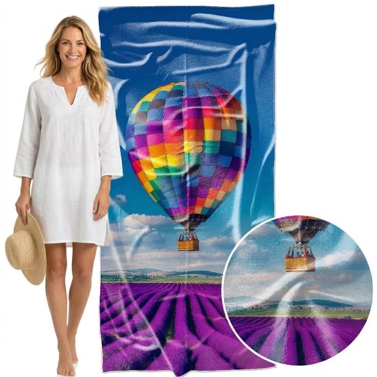 Modelka w ciemnym stroju obok pionowo zawieszonego ręcznika XXL Serena 100x180 z radosnym wzorem letnim, zbliżenie - TwójDomNa5.pl