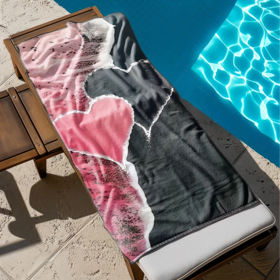 Ogromny ręcznik plażowy XXL z różowym sercem rozłożony w całości na drewnianym leżaku przy basenie