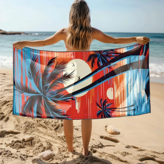 Kobieta stojąca tyłem trzymająca rozłożony ręcznik z mikrofibry z nadrukiem letniego zachodu słońca i czarnych palm na plaży