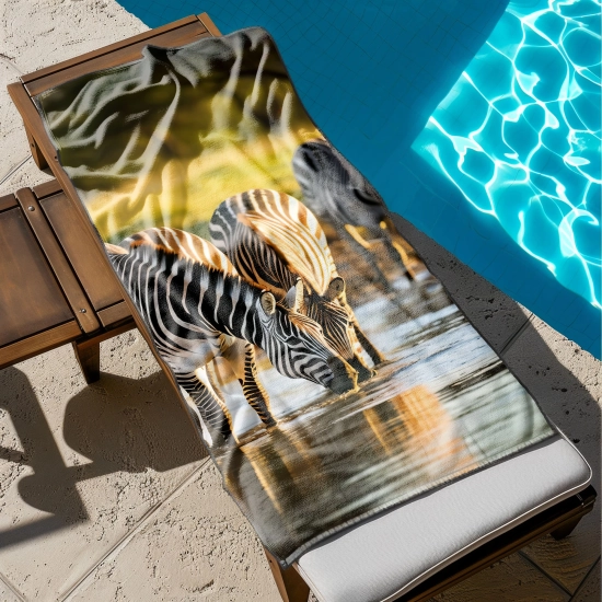 Mały ręcznik do bagażu z nadrukiem dzikich zwierząt rozłożony na drewnianym leżaku przy błękitnym basenie