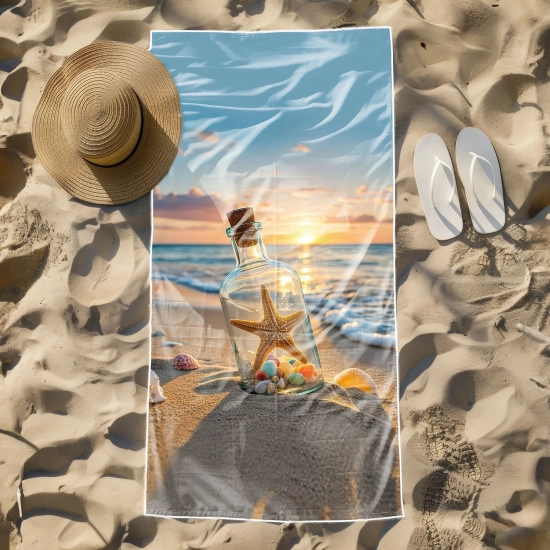 Odporny na piasek ręcznik na leżak hotelowy ze zdjęciem butelki i oceanu, leżący obok słomkowego kapelusza i białych klapek