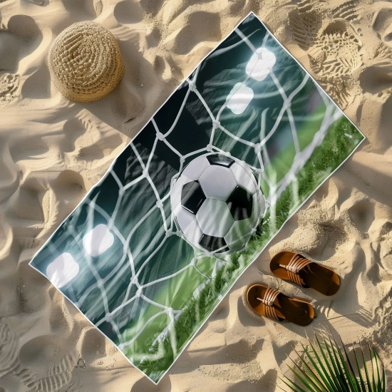 Ręcznik plażowy niełapiący piasku ze wzorem strzelonego gola ułożony na piasku