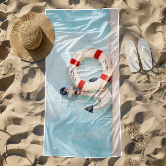 Kompaktowy ręcznik żeglarski z mikrofibry z kołem ratunkowym leżący na plaży przy klapkach
