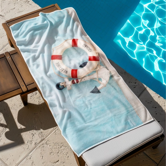 Chłonny ręcznik na basen ze wzorem morskim rozłożony na drewnianym leżaku - TwójDomNa5.pl