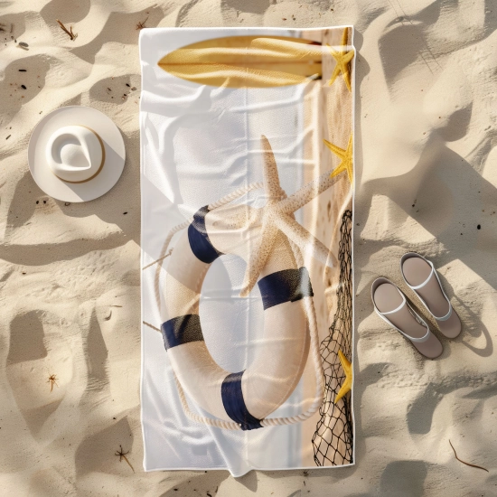 Ręcznik plażowy Sand-Free z rozgwiazdą i deską ułożony na piasku obok kapelusza