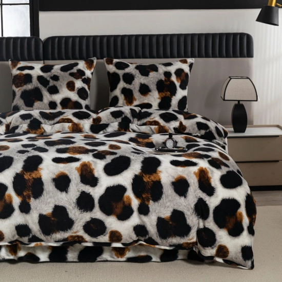 Pościel pluszowa w zwierzęcy wzór panterki rozścielona na materacu przed ciemnym zagłówkiem