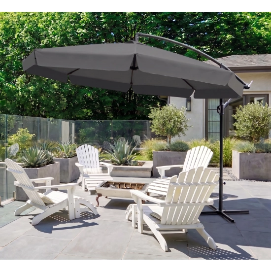 Duży parasol Solano (350 cm) w kolorze ciemnoszarym (antracytowym) z dekoracyjną falbaną, rzucający cień na zestaw ogrodowy na tarasie, w otoczeniu zieleni.
