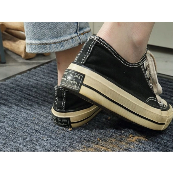 Wycieraczka w użyciu, z butami na niej, ilustrująca jej efektywność w usuwaniu brudu