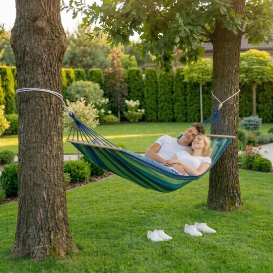 Para odpoczywająca w niebiesko-zielonym hamaku ogrodowym z poduszką