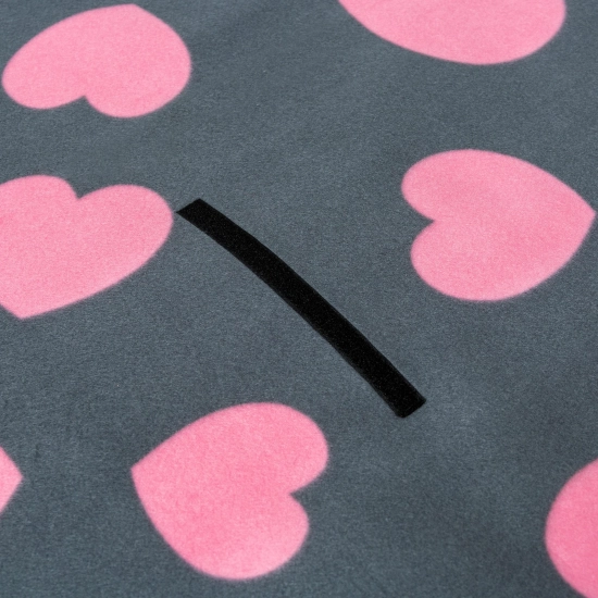 Zbliżenie na mocny, czarny rzep mocujący na miękkiej polarowej powierzchni w urocze, różowe serca.