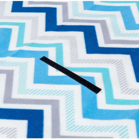 Zbliżenie na mocny, czarny rzep mocujący na miękkiej polarowej powierzchni w niebieskie i błękitne zygzaki.