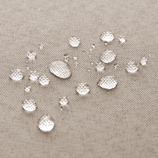 Krople wody spływające po hydrofobowej tkaninie beżowych zasłon ogrodowych potwierdzające wodoodporność