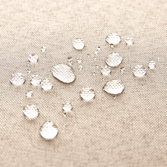 Krople wody utrzymujące się na powierzchni hydrofobowej tkaniny kremowej zasłony ogrodowej, potwierdzające wodoszczelność