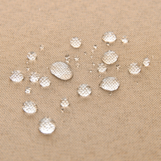 Test wodoszczelności piaskowej tkaniny zasłony ogrodowej z perliącymi się kroplami wody na powierzchni